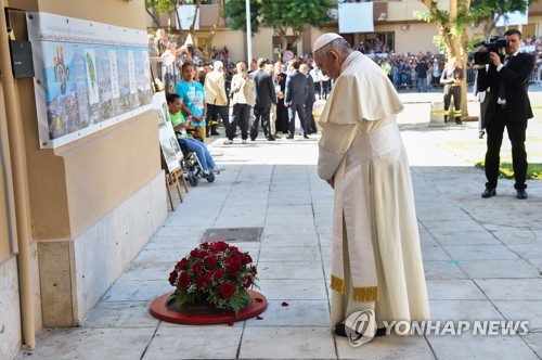 프란치스코 교황이 25년 전 풀리시 신부가 마피아에 살해된 장소를 찾아 헌화하고 있다.[AFP=연합뉴스]