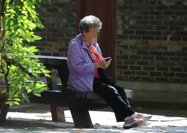 30일 오전 서울 한 공원에서 노인이 휴대폰을 들여다보고 있다. 신소영 기자 viator@hani.co.kr