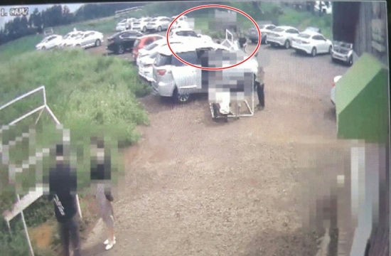 지난달 4일 제주시 한림읍 한 목장에서 발생한 2세 여아 사망사고 직전 모습.  흰색 경차(붉은색 선 원안)가 주차장을 빠져나오고 있다.  CCTV영상 캡처