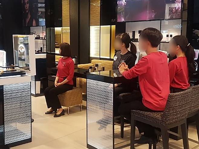 지난 2일 오후 ‘백화점면세점화장품노조연대’ 직원들이 대기 시간에 앉을 수 있는 권리를 알리기 위해 매장에서 ‘앉기 행동’을 하고 있다. 사진 전국서비스산업노동조합연맹