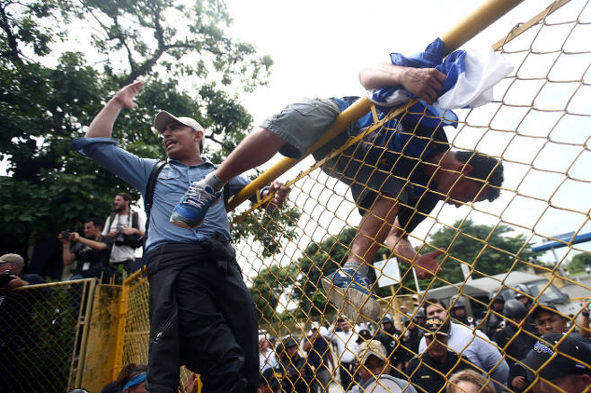 과테말라와 멕시코 사이의 국경 철조망을 넘는 온두라스 이민자들. 로이터=연합뉴스