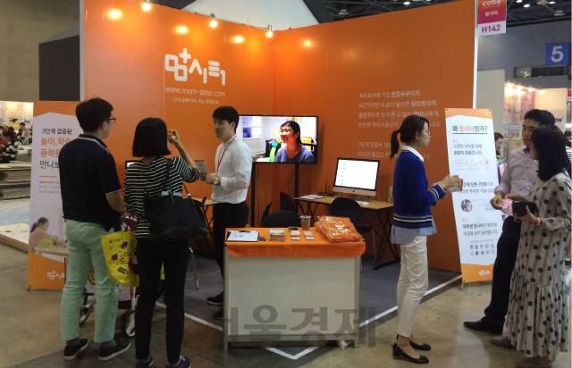 맘시터 임직원들이 코베박람회에 참가해 부모들에게 자사의 시터 이용 시스템을 설명하고 있다./사진제공=맘시터