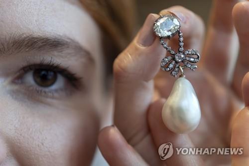 경매업체 소더비 직원이 마리 앙투아네트가 소유했던 다이아몬드 진주 목걸이 펜던트를 들어 보이고 있다. 이 보석들은 14일(현지시간) 경매에 출품된다. [EPA=연합뉴스]
