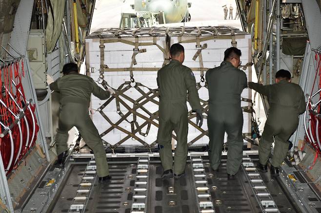 공군장병들이 지난 11일 오후 제주국제공항에서 북한에 보낼 제주산 감귤을 공군 C-130 수송기에 싣고 있다. 국방부 제공.
