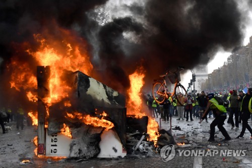 지난 24일(현지시간) 프랑스 파리 샹젤리제 거리에서 벌어진 '노란 조끼' 시위에서 불타고 있는 트럭 [AFP=연합뉴스]