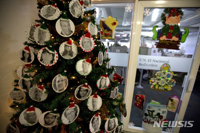 【AP/뉴시스】마지막 호를 만드는 13일 기자들과 편집진의 얼굴로 만든 크리스마스 트리가 편집국 입구에 서있다.