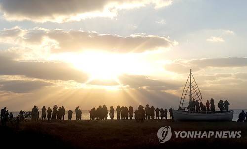 제주 광치기해변 일출 풍경 (서귀포=연합뉴스) 전지혜 기자 = 무술년 첫날인 1일 일출 명소인 제주 서귀포시 성산일출봉 인근 광치기해변에서 해맞이객들이 새해 첫 해돋이를 감상하고 있다. 2018.1.1 atoz@yna.co.kr