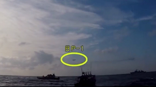 국방부가 4일 광개토대왕함 상공에 저고도로 진입한 일본 초계기의 모습(노란 원)을 촬영한 동영상을 유튜브에 공개했다.   /연합뉴스