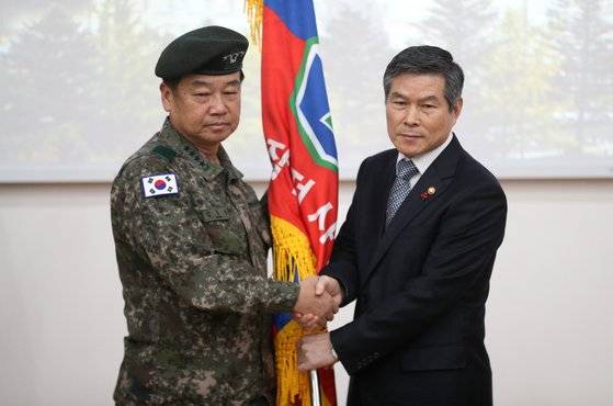 정경두 국방부 장관(오른쪽)이 9일 오전 경기도 용인시 처인구 지상작전사령부에서 열린 사령부 창설식에서 김운용 초대 지상작전사령관(육군 대장)에게 지작사기를 전달하며 악수를 하고 있다. 김경록 기자