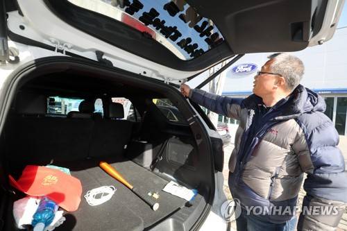 '수리 흔적 보세요' (전주=연합뉴스) 정경재 기자 = 20일 오후 전북 전주시 덕진구 포드 자동차 전시관 앞에서 한 차주가 "중고차를 신차로 속여 팔았다"며 수리 흔적을 손으로 가리키고 있다. 2019.1.20 jaya@yna.co.kr