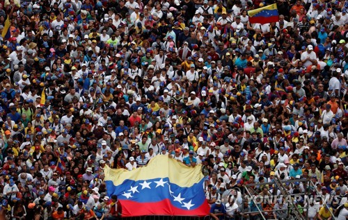 니콜라스 마두로 대통령의 퇴진을 요구하는 반정부 집회 참가자들이 국기를 들고 있다. [로이터=연합뉴스]