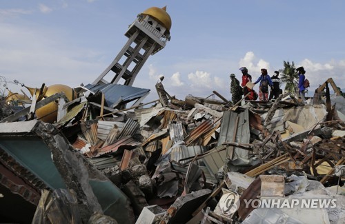 2018년 10월 6일 인도네시아 중앙술라웨시 주 팔루 시내 발라로아 지역에서 주민들이 지반 액상화 현상으로 무너진 잔해에 묻힌 가족들을 찾고 있다. [AP=연합뉴스자료사진]