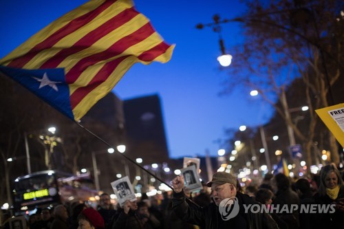 지난 1일 스페인 바르셀로나의 유럽연합 사무소 앞에서 카탈루냐 분리독립 지지자들이 수감된 전 카탈루냐 자치정부 지도자들의 사진과 카탈루냐기 '에스텔라다'를 흔들고 있다.   [AP=연합뉴스]