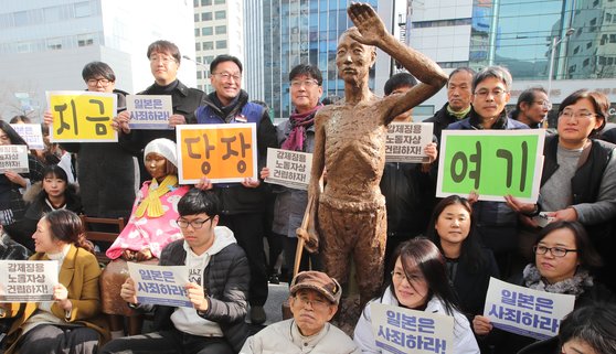 지난해 12월 부산에서 강제징용 피해자를 추모하는 시민단체 회원들이 강제노동자상을 일본 총영사관 앞으로 옮긴 뒤 기념촬영을 하고 있다. 송봉근 기자