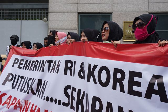 [저작권 한국일보]㈜에스카베(SKB) 노동자들이 ‘인도네시아와 한국 정부는 언제 내 월급을 돌려줄 것인가’라는 문구를 들고 14일 주인도네시아한국대사관 앞에서 집회하는 모습. 자카르타=고찬유 특파원