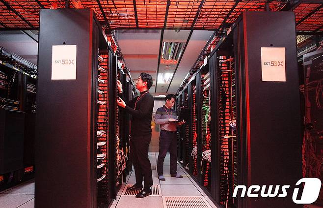 SK텔레콤 직원들이 성수 교환국사에서 양자난수생성기가 적용된 가입자 인증서버를 점검하고 있는 모습. (SKT 제공) © 뉴스1