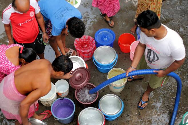인도 콜카타 지역 빈민촌에서 수돗물을 공급받기 위해 주민들이 물통을 가져다 놓은 모습. [EPA=연합뉴스]