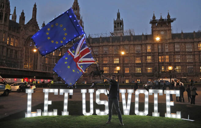 27일 저녁 영국 하원이 브렉시트 대안 8개안에 대한 표결을 진행하던 시각에 의사당 바깥에 글로벌 시민단체 아바즈가 “우리가 투표하게 하라”는 주장을 담은 전광 불빛이 빛나고 있다. 런던/AP 연합뉴스