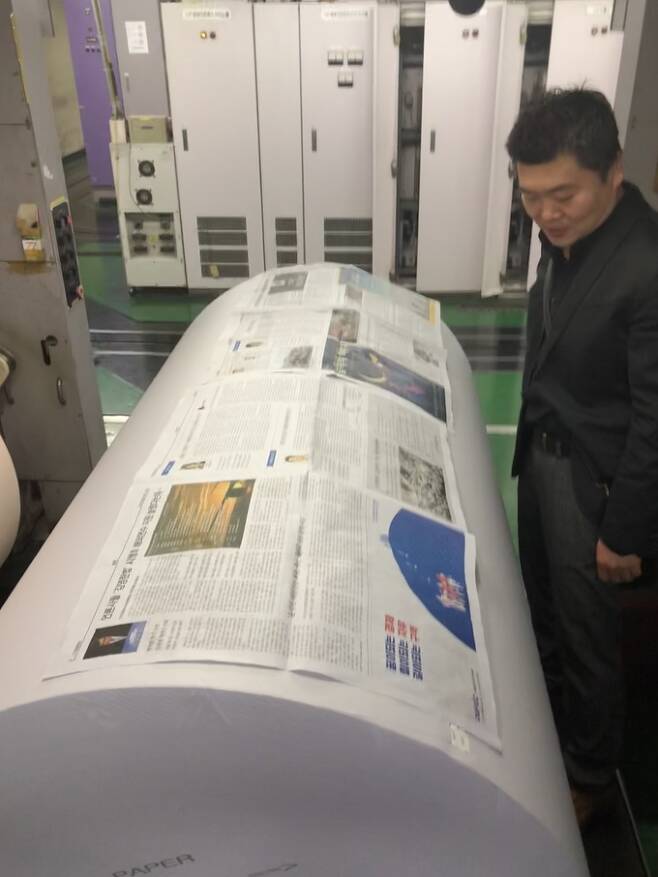 배병관 서울신문 제작국 과장이 신문용지 위에 신문을 얹어 보고 있다. 신문용지는 신문 4개면을 펼쳐놓은 만큼의 폭이다.