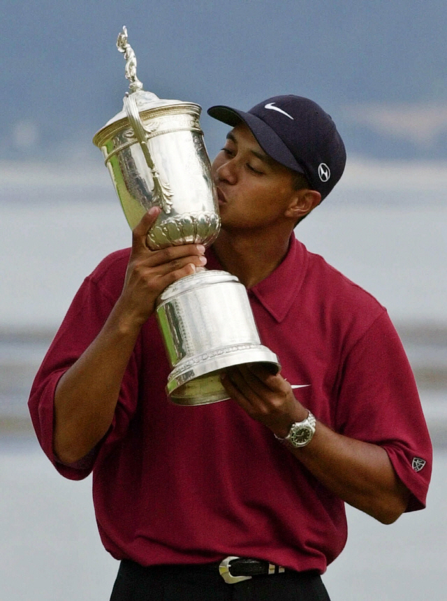 FILE - In this June 18, 2000, file photo, Tiger Woods kisses the winner's trophy after capturing the 100th U.S. Open Golf Championship at the Pebble Beach Golf Links in Pebble Beach, Calif. He won the U.S. Open by a record 15 strokes. Woods completes an amazing journey by winning the 2019 Masters, overcoming 11 years of personal foibles and professional pain that seemed likely to be his lasting legacy. (AP Photo/Elise Amendola, File)        <저작권자(c) 연합뉴스, 무단 전재-재배포 금지>