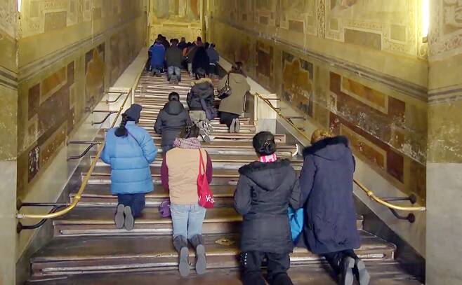 나무 덮개가 제거 되기 전의 '성 계단'에서 순례자들이 무릎으로 계단을 오르고 있다. [사진 유튜브 캡쳐]