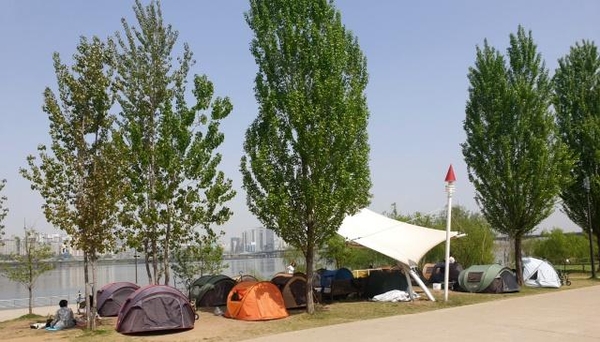 22일 오후 여의도 한강공원에서 시민들이 텐트를 치고 휴식을 취하고 있다. 4면 모두를 가려놓은 텐트가 곳곳에 보인다. /박소정 기자