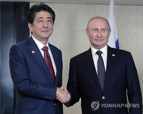 아베 신조 일본 총리(왼쪽)와 블라디미르 푸틴 러시아 대통령이 작년 11월 싱가포르에서 만나 악수를 나누는 모습 [EPA=연합뉴스 자료사진]