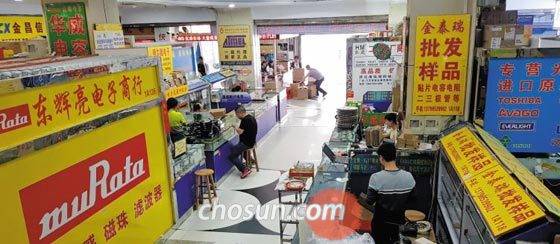 지난 17일 중국 선전시 화창베이의 신야저우 전자상가 1층 매장에서 상인들이 가게에 앉아 스마트폰으로 게임을 하거나 잡담을 나누고 있다. 중국 최대 전자상가인 화창베이는 최근 고객이 크게 줄면서 가게 문을 닫는 상인이 많아졌다. /오로라 기자