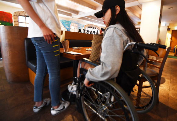 - 서울 혜화역 인근에서 SUNNY들이 장애인 문화시설 지도를 제작하기 위해 한 음식점을 찾아 휠체어를 타고 테이블 높이를 측정하고 있다.