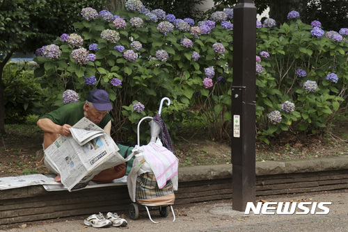 【도쿄=AP/뉴시스】일본 도쿄 우에노 공원에서 5일 한 노인이 신문을 읽고 있다. 2017.07.05