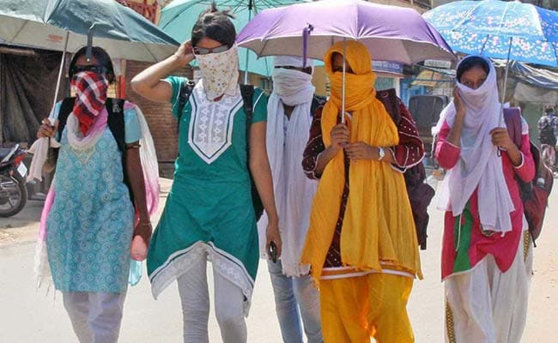 폭염이 기승을 부리고 있는 인도에서 주민들이 더위를 피하기 위해 우산을 쓰고 마스크를 끼고 있는 모습. /NDTV