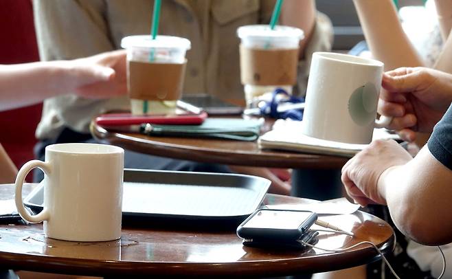 서울 시내 한 카페 내에서 고객들이 머그잔과 일회용 컵을 이용하고 있다. 커피전문점과 패스트푸드점 등을 대상으로 한 일회용컵 남용 단속은 지난해 8월2일부터 시작됐다. <연합뉴스>