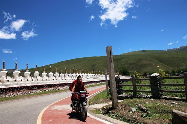 오토바이를 타고 이동하는 티베트 승려의 모습이 낯설고 이색적이다.