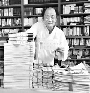 조정래 소설가가 `천년의 질문`의 육필 원고와 130개가 넘는 취재수첩 앞에서 웃고 있다.