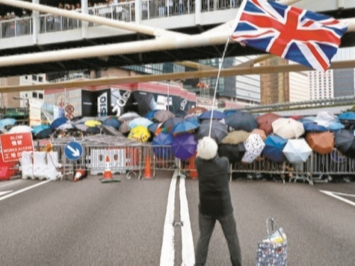홍콩 주민들의 반중 시위를 진압하기 위해 출동한 경찰 바로 앞에서 영국 국기 ‘유니언잭’이 힘차게 휘날리고 있다. AP뉴시스