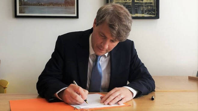 크리스 스키드모어 영국 에너지부 장관이 탄소 중립 법안에 최종 서명하고 있다. / 사진=영국 에너지부