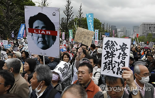 작년 4월 도쿄 국회의사당 앞에서 열린 아베 정권 퇴진 요구 시위에서 시민들이 행진하는 모습. '아베는 거짓말쟁이', '아베 내각 총사퇴' 등의 구호가 보인다. [EPA=연합뉴스 자료사진]