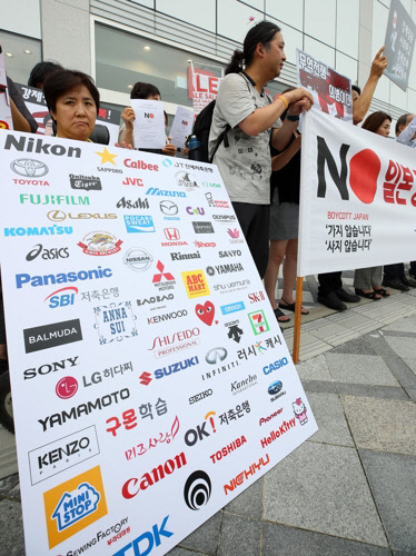 지난 18일 세종시 유니클로 세종점 앞에서 시민단체 회원들이 일본 브랜드 리스트를 보여주며 불매운동 동참을 촉구하고 있다. <연합뉴스>