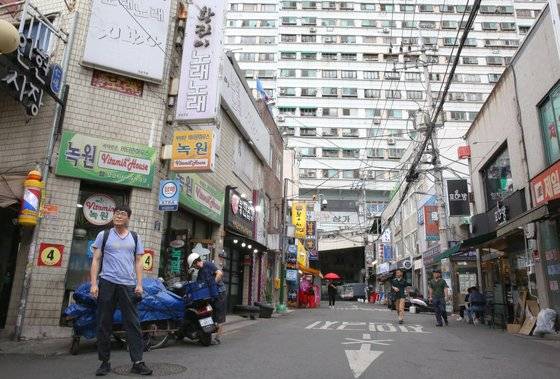 인현시장 입구 골목. 정면에 보이는 거대한 건물이 진양상가다. 재개발 논란으로 시끄럽다. 사진 왼쪽으로 시장 골목이 이어지고 상가 앞으로 인쇄 골목이 이어진다. 손민호 기자