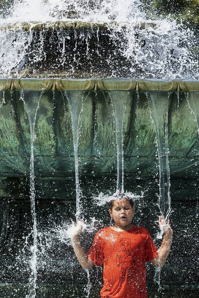 미국의 한 어린이가 21일(현지시간) 필라델피아의 이킨스 오벌 분수에서 더위를 식히고 있다. 필라델피아|AP연합뉴스