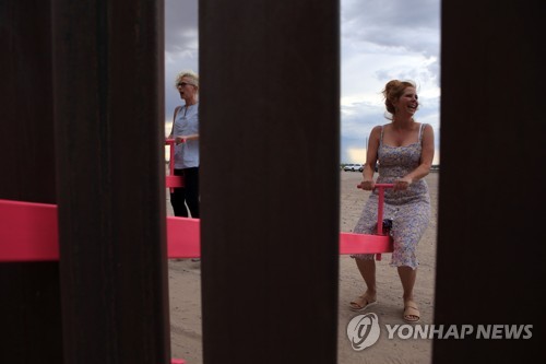 미국-멕시코 국경 장벽에 설치된 시소 즐기는 미국 가족 [AFP=연합뉴스]