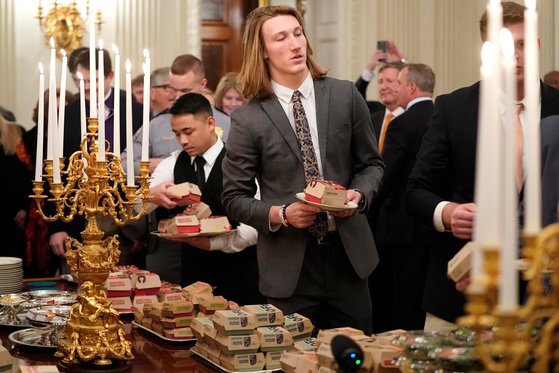 2018년 미국 대학 풋볼 리그에서 우승한 클램슨 타이거팀 소속 미식 축구 선수들이 지난 1월 백악관에 초청돼 햄버거로 저녁 식사를 하고 있는 모습. 트럼프 대통령은 평소 햄버거를 즐겨 먹는 것으로 알려져 있다. [로이터=연합뉴스]