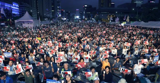 지난 15일 오후 서울 광화문광장에서 열린 ‘8·15 아베 규탄 범국민 촛불문화제’에 참석한 시민들이 손피켓과 촛불을 들고 일본 아베 정권의 역사 왜곡과 경제 보복 조치를 규탄하고 있다. 최승식 기자