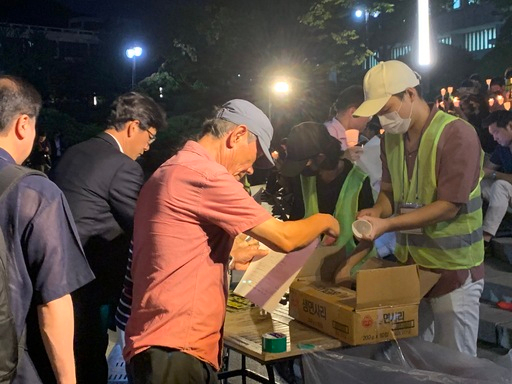 서울대 촛불집회 주최 측이 참가자들에게 양초와 종이컵을 나눠주고 있다.