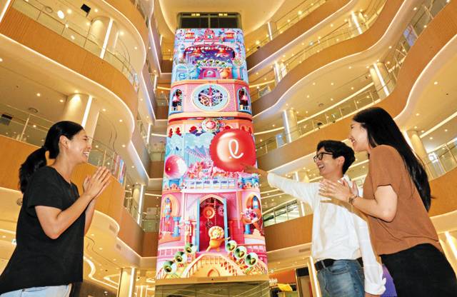 30일 오픈하는 롯데몰 수지점에서 직원들이 LED 전광판 ‘미디어타워’를 바라보고 있다. 높이 24m인 이 전광판에선 미디어 아트(영상이나 컴퓨터를 기반으로 한 예술)가 상영되고, AR(증강현실) 기술을 적용해 고객들이 게임에 참여할 수 있다. /김연정 객원기자