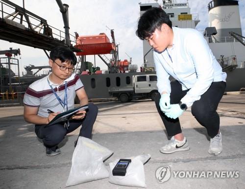 (동해=연합뉴스) 이해용 기자 = 2일 오후 강원 동해시 동해항에서 원주지방환경청 관계자들이 일본에서 수입한 석탄재 시료의 방사선을 측정하고 있다.