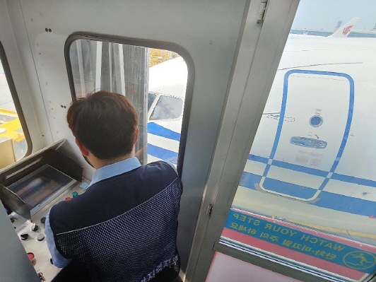 인천공항 탑승교 근무자가 항공기에 접현하고 있다.