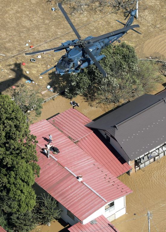 13일 태풍 '하기비스'가 몰고온 폭우 속에 침수된 일본 미야기현 마루모리에서 헬기가 출동해 지붕 위로 대피한 주민들을 구조하고 있다. 연합뉴스