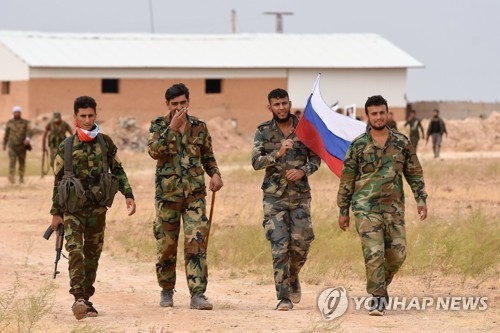 16일 시리아 탑까 공군기지에서 러시아 국기를 흔드는 시리아군 [AFP=연합뉴스]