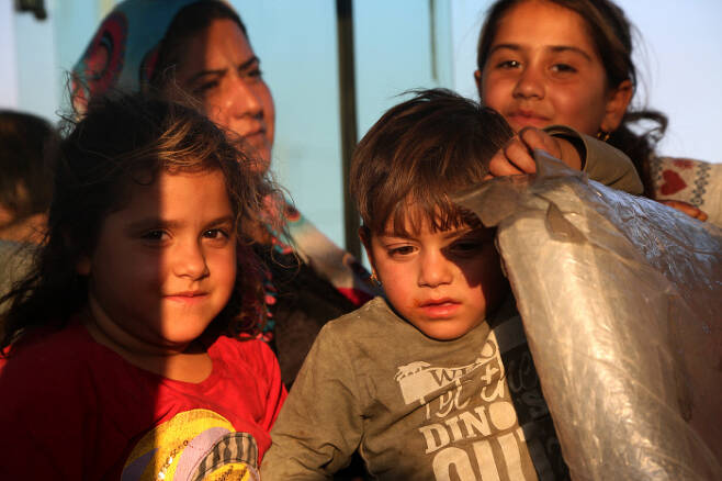 터키군의 침공을 피해 시리아 북부에서 도망쳐온 쿠르드족 주민들이 16일 이라크 북부 두호크의 브라다스르슈 난민촌에 도착하고 있다.  두호크 | EPA연합뉴스